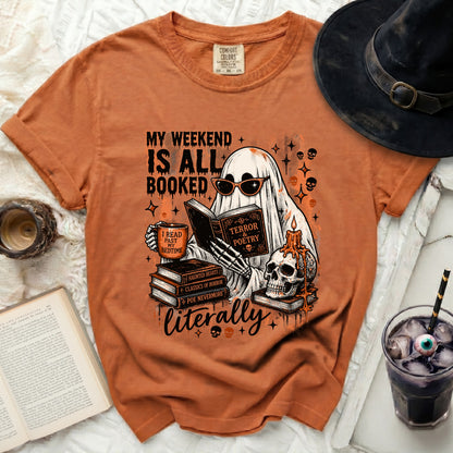Orange t-shirt graphic features a ghost reading with books, skulls, and text.