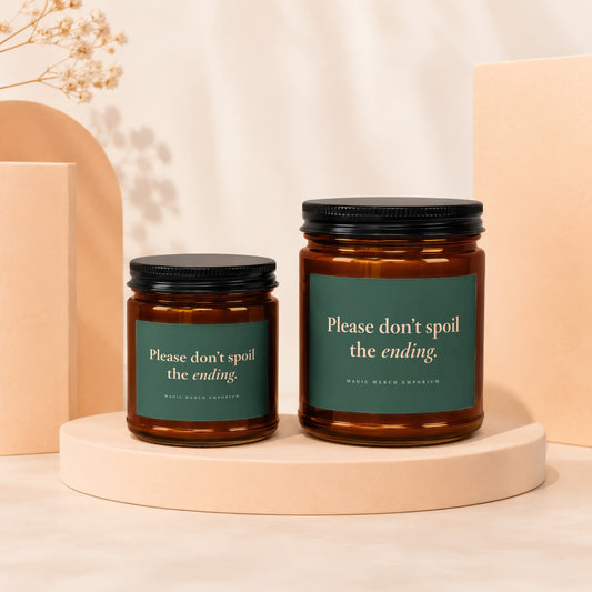 Two amber glass candles with dark lids and green labels reading "Please don't spoil the ending."