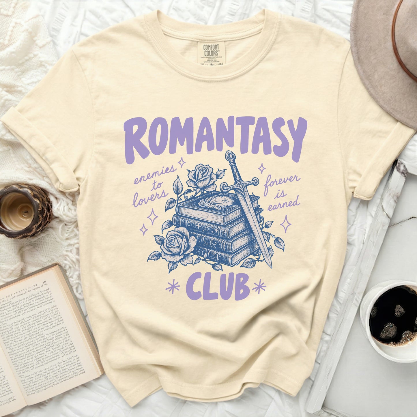 Cream shirt with "ROMANTASY CLUB" text and sword, books, and roses graphic.