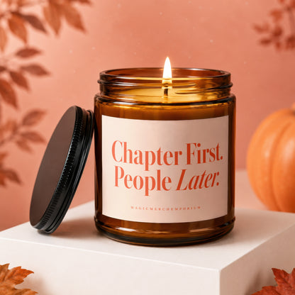 Amber jar candle with lit wick, lid off, reading "Chapter First. People Later."