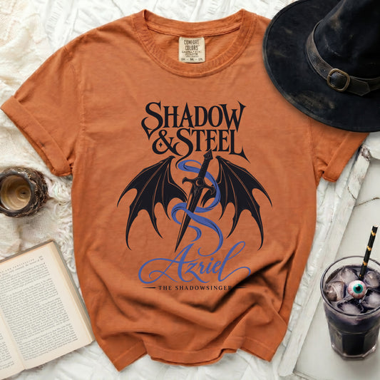 Orange t-shirt with "Shadow & Steel" text, sword, dragon wings, and "Azriel"