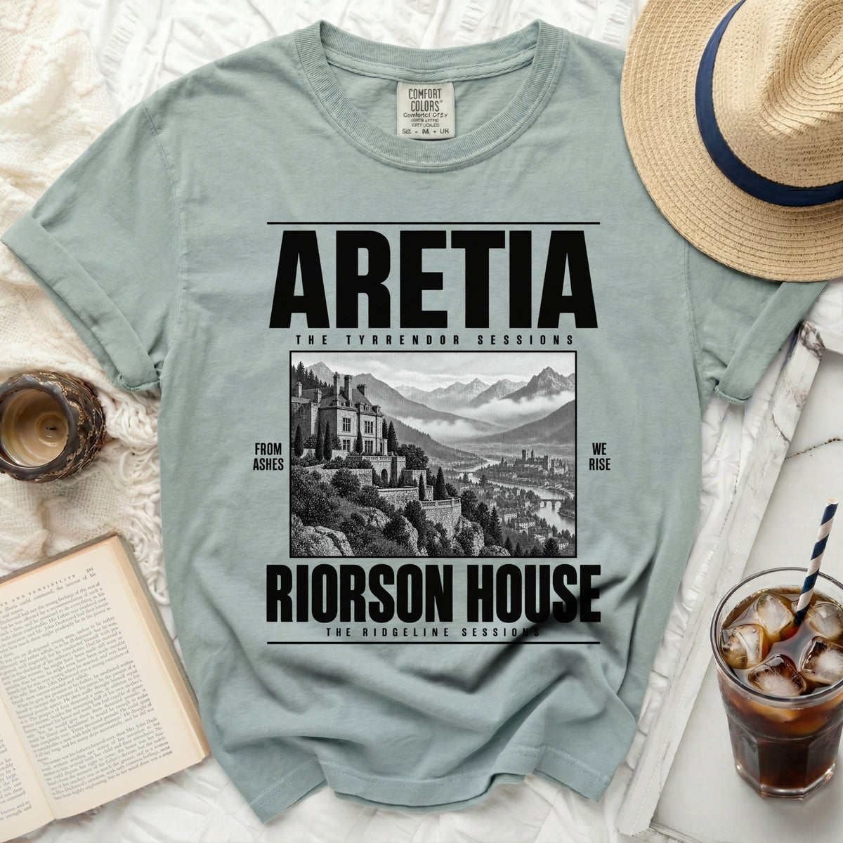 Light green t-shirt with black text "ARETIA", "RIORSON HOUSE", "FROM ASHES", and "WE RISE".