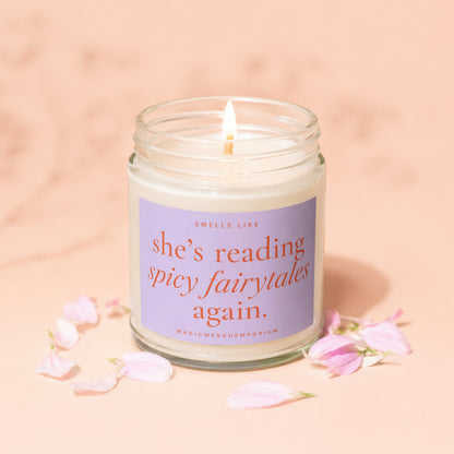 Lit candle in jar with purple label that reads "smells like she's reading spicy fairytales again."