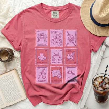 Pink t-shirt with fairytale stamps: "Touch Her & Die," "Here Comes The Smut," "My Book Boyfriend," and more.