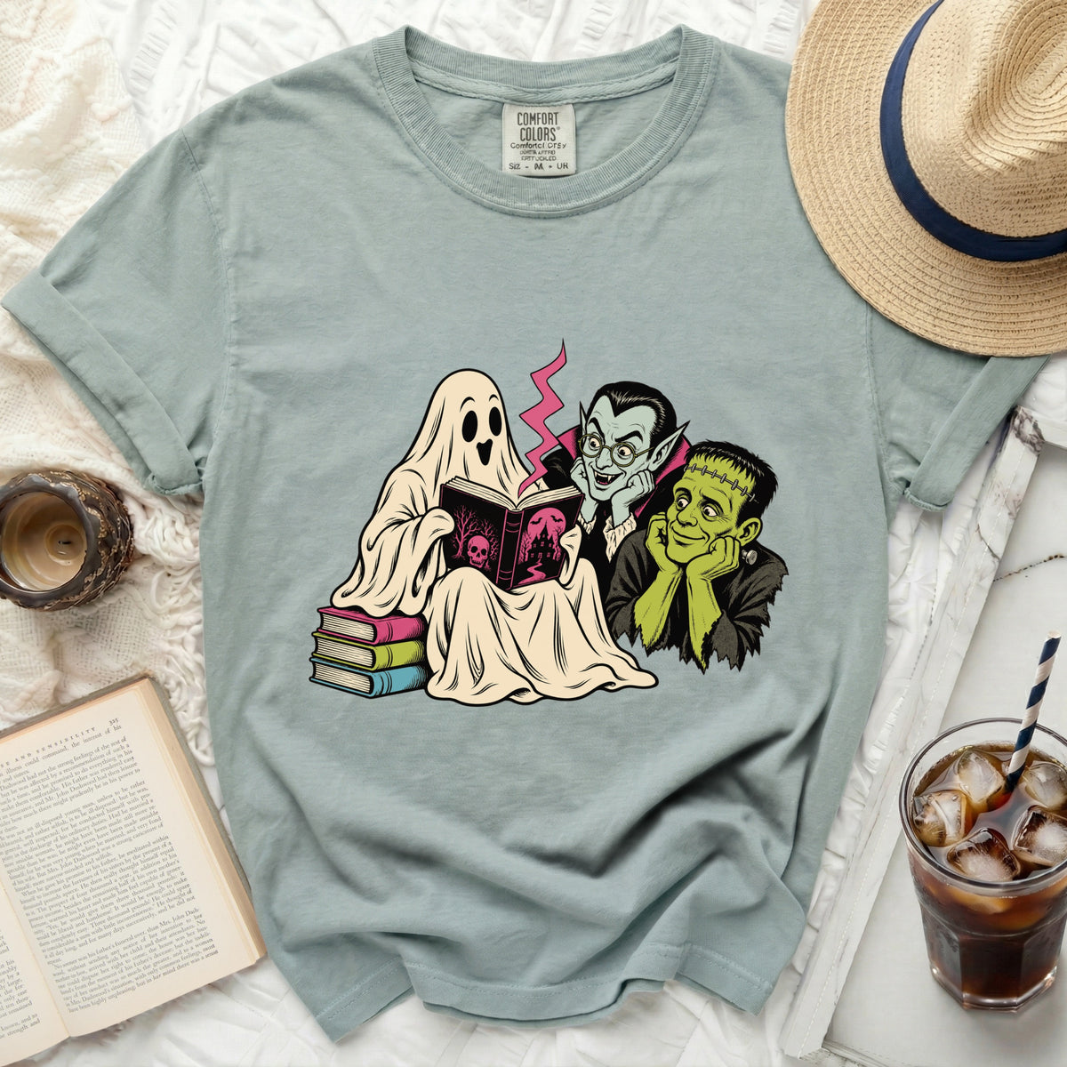 Ghost, vampire, and Frankenstein characters reading a spooky book.