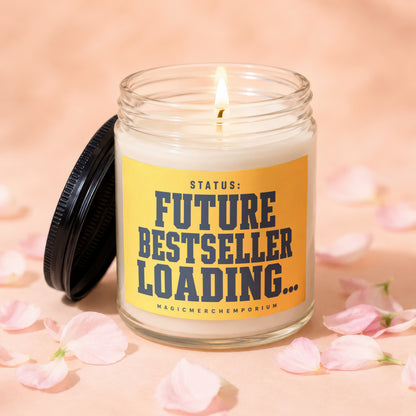 Glass candle with lit wick, yellow label reading "STATUS: FUTURE BESTSELLER LOADING..."