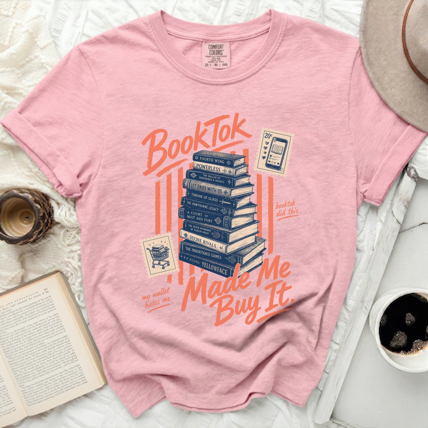Pink t-shirt with "BookTok" and "Made Me Buy It" text over stacked books.