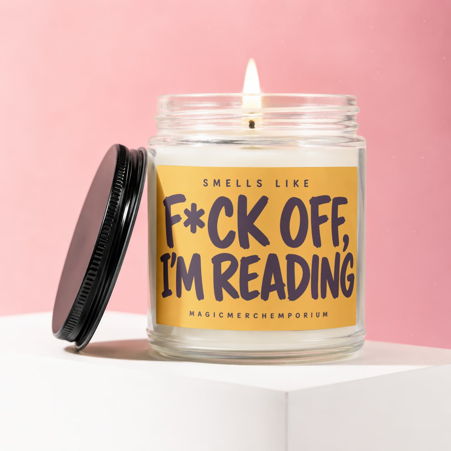 Candle with text "Smells Like F*ck Off, I'm Reading" on a yellow label.