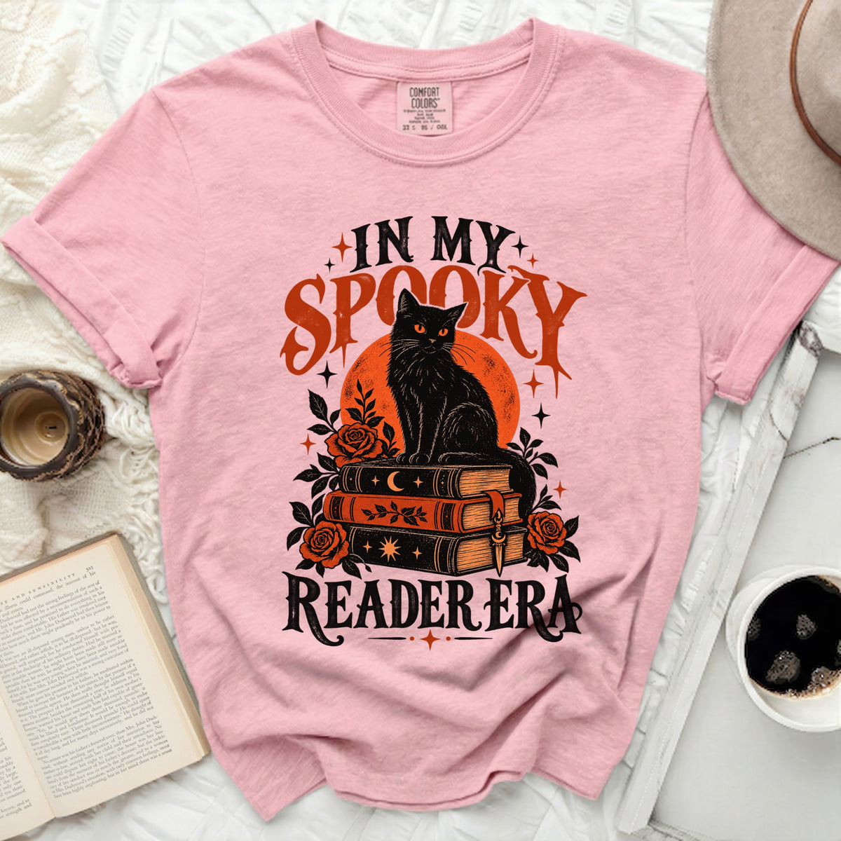 Pink t-shirt with black cat, books, roses, and "In My Spooky Reader Era" text.