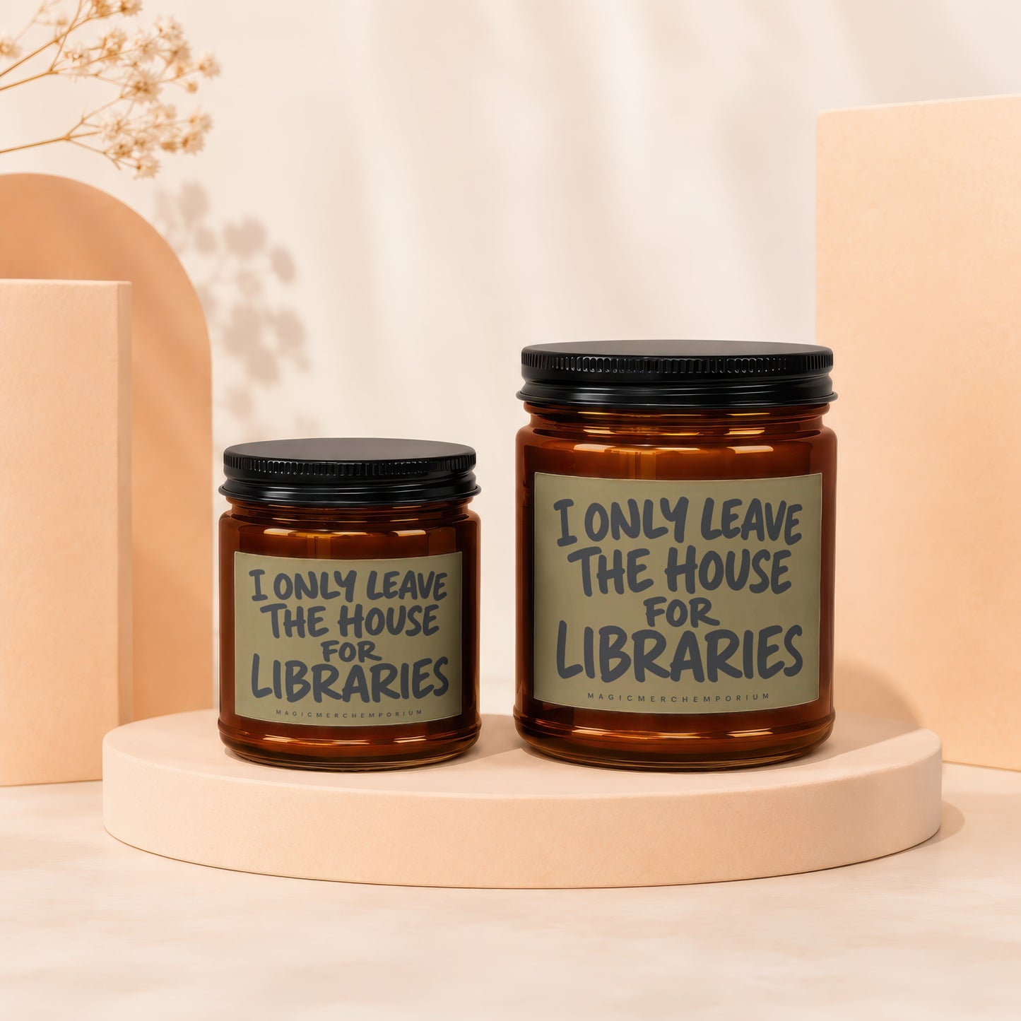Two amber glass candles with black lids feature labels reading "I ONLY LEAVE THE HOUSE FOR LIBRARIES."