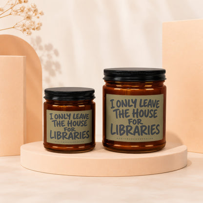 Two amber glass candles with black lids feature labels reading "I ONLY LEAVE THE HOUSE FOR LIBRARIES."