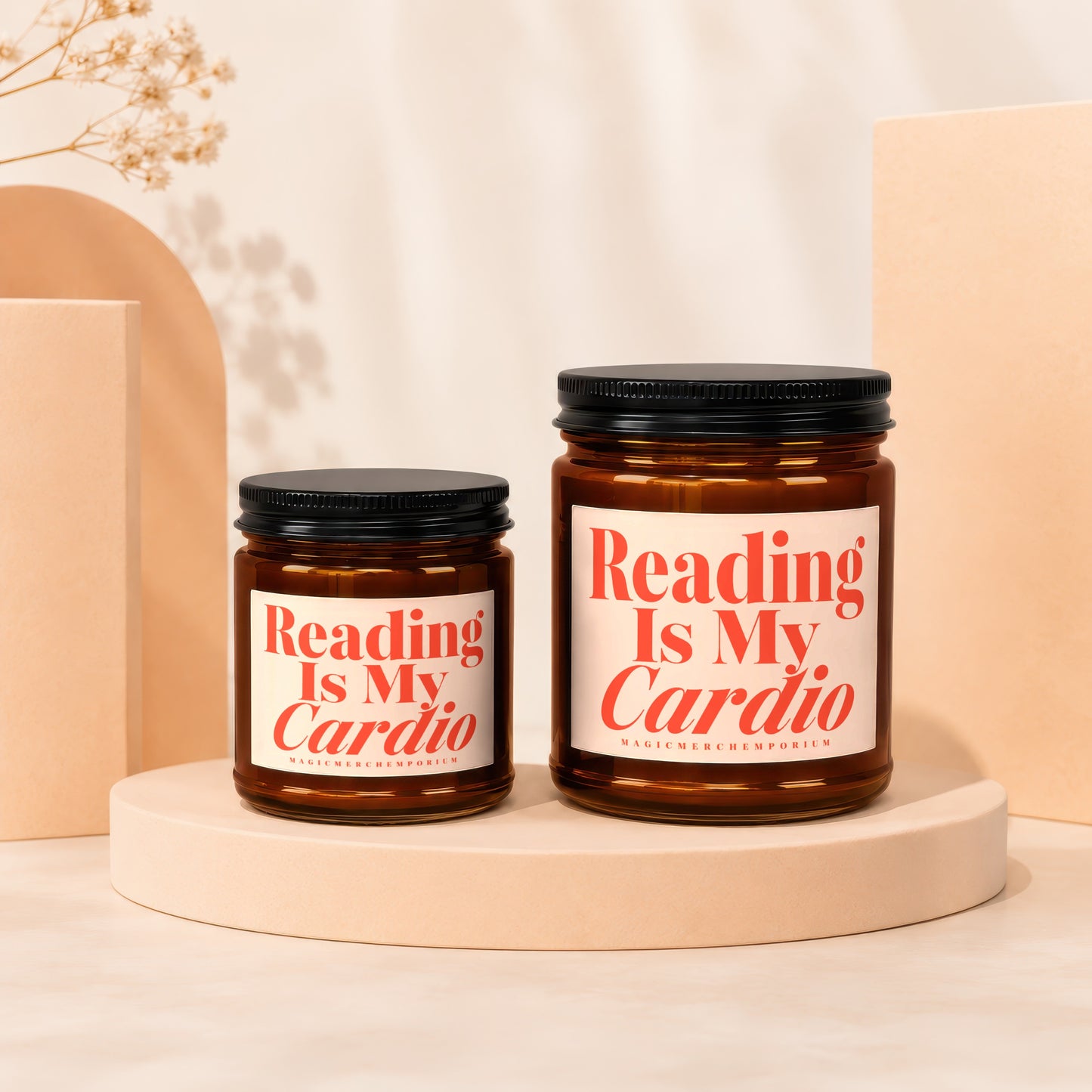 Two amber glass candles with black lids, one small and one large, featuring red text.