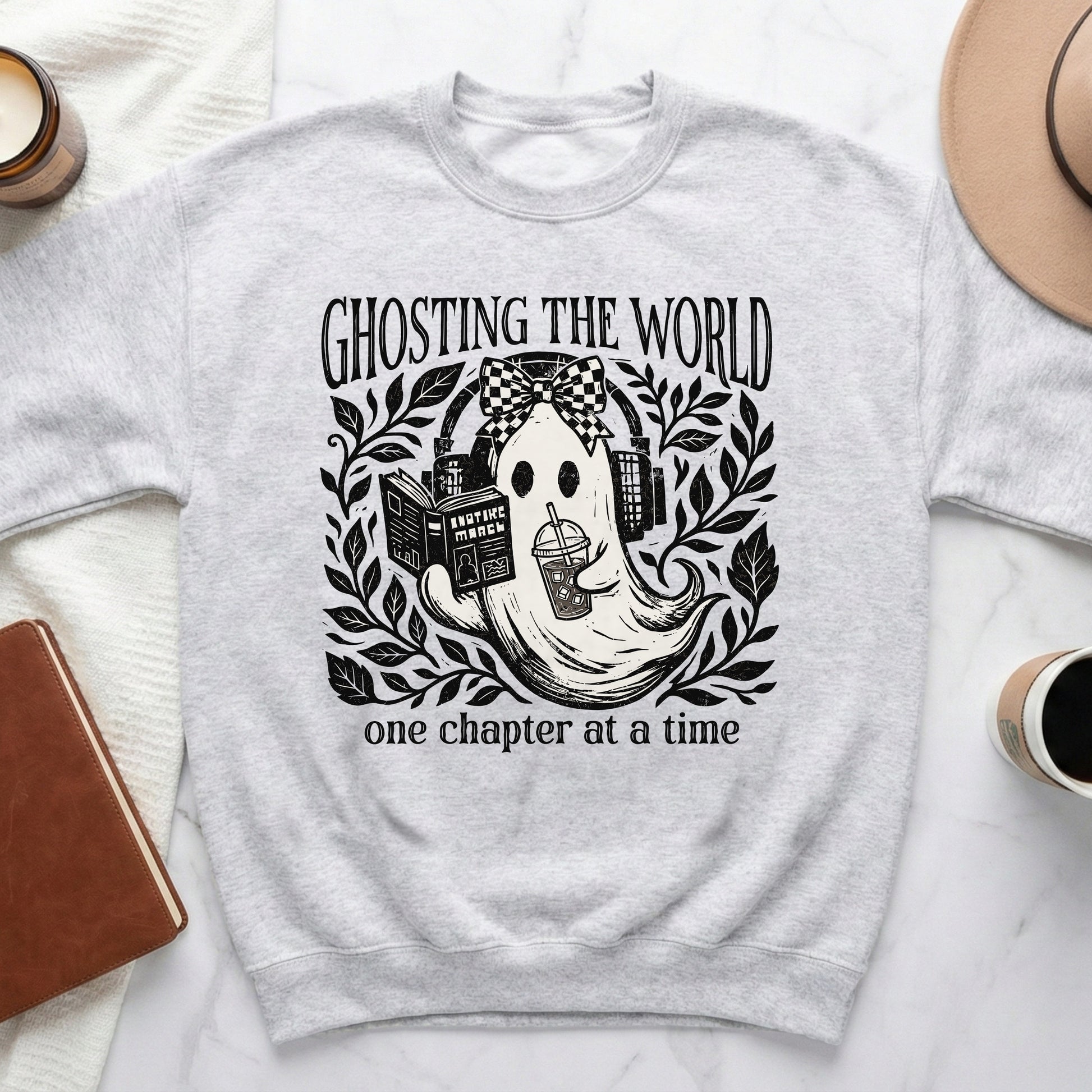 Light gray sweatshirt with a ghost graphic reading "Ghosting the world, one chapter at a time."