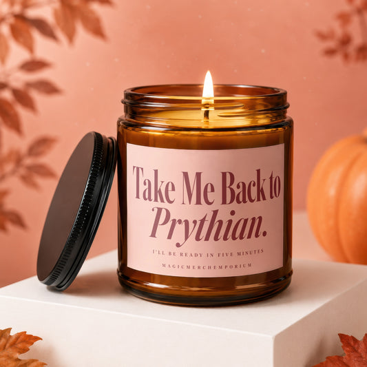 Lit amber glass candle with "Take Me Back to Prythian" label.