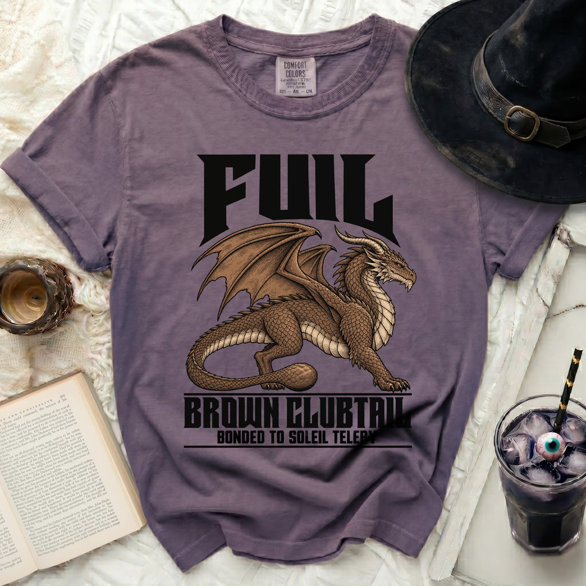 Purple t-shirt with a brown dragon graphic and text "FUIL BROWN CLUBTAIL BONDED TO SOLEIL TELERY".