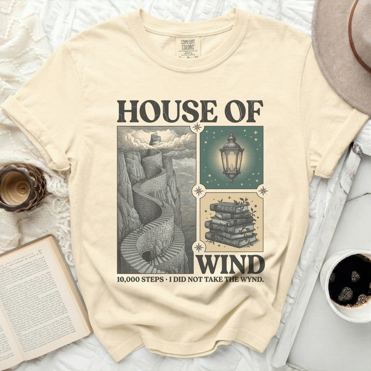T-shirt with "House of Wind" design featuring stairs, lantern, and books.