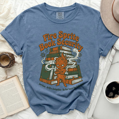 Blue t-shirt with "Fire Sprite Book Security" graphic featuring a fiery creature on a stack of books.