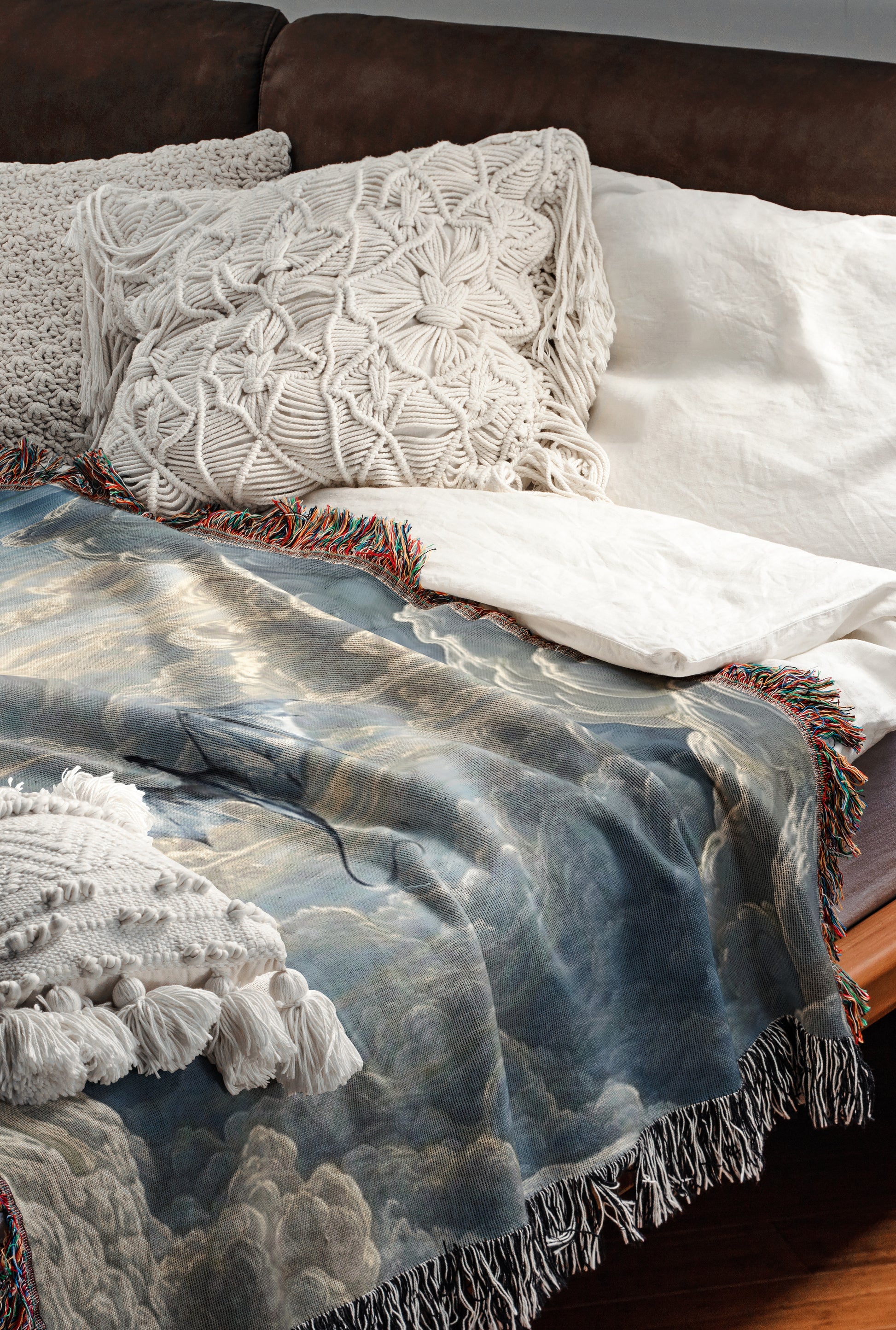 a cozy and inviting bedroom scene, featuring a bed with a blue and white patterned blanket and a white pillow. The bed is set against a brown leather headboard, creating a warm and comfortable atmosphere.