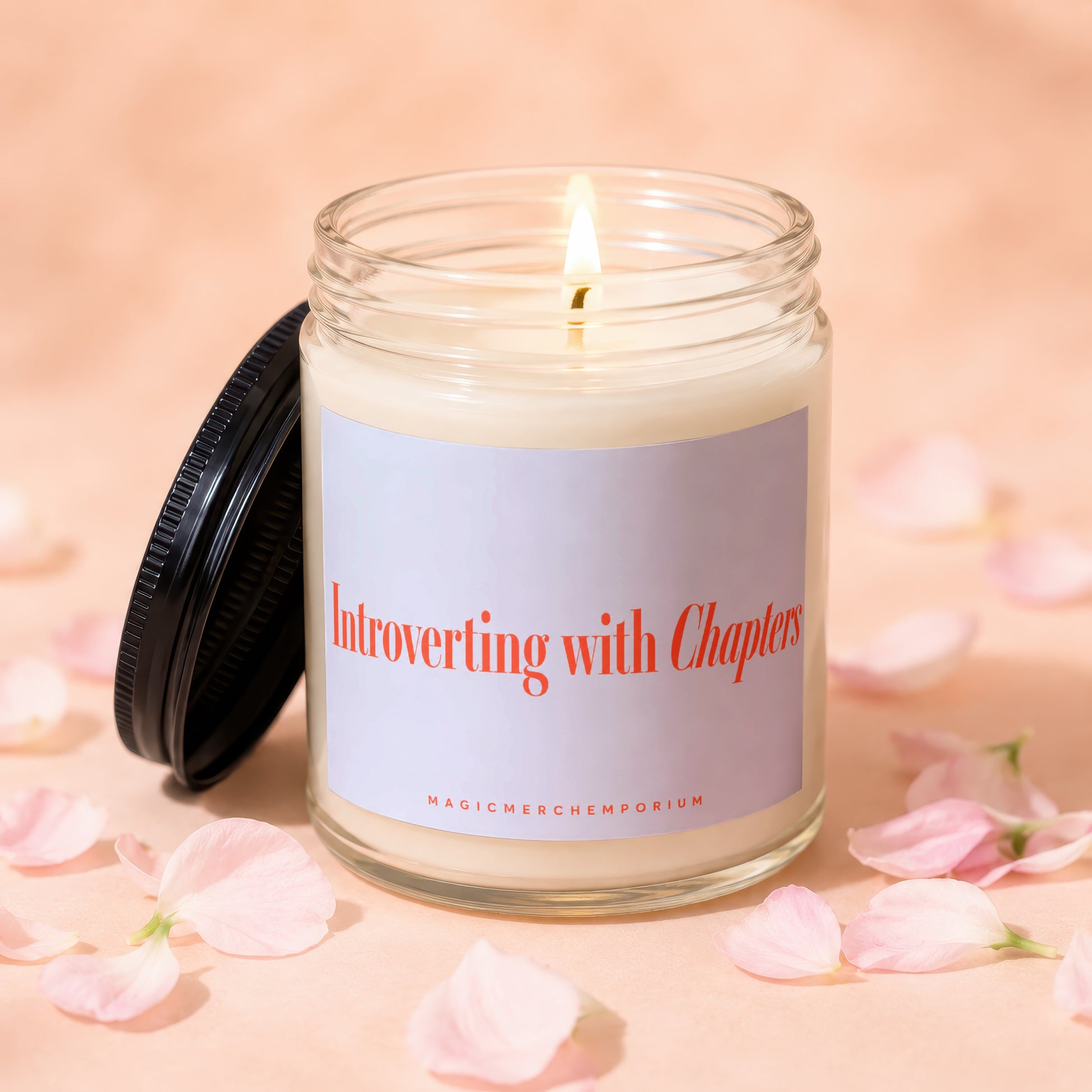 Candle with "Introverting with Chapters" text and a black lid, surrounded by pink petals.