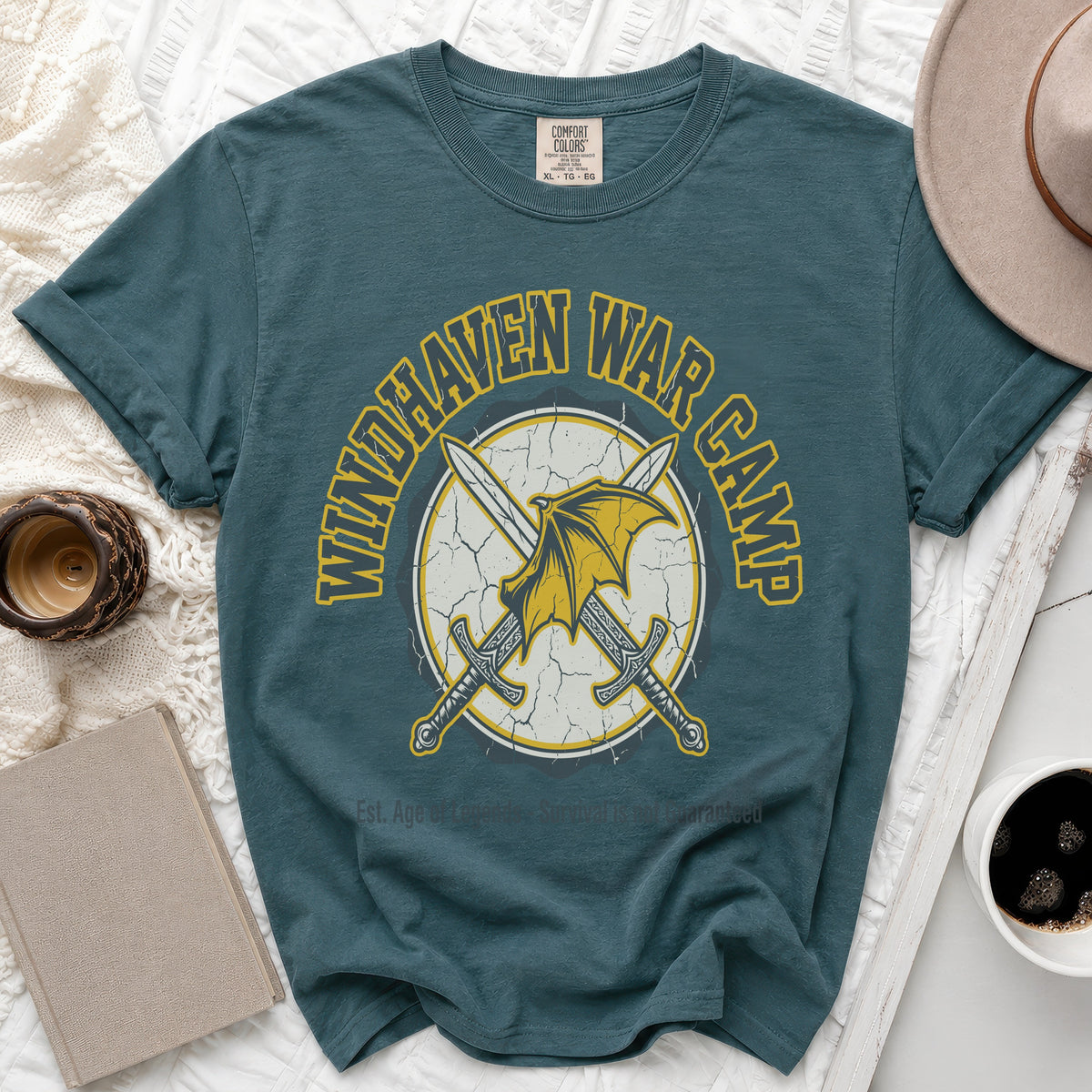 Teal t-shirt with "Windhaven War Camp" text and crossed swords graphic.