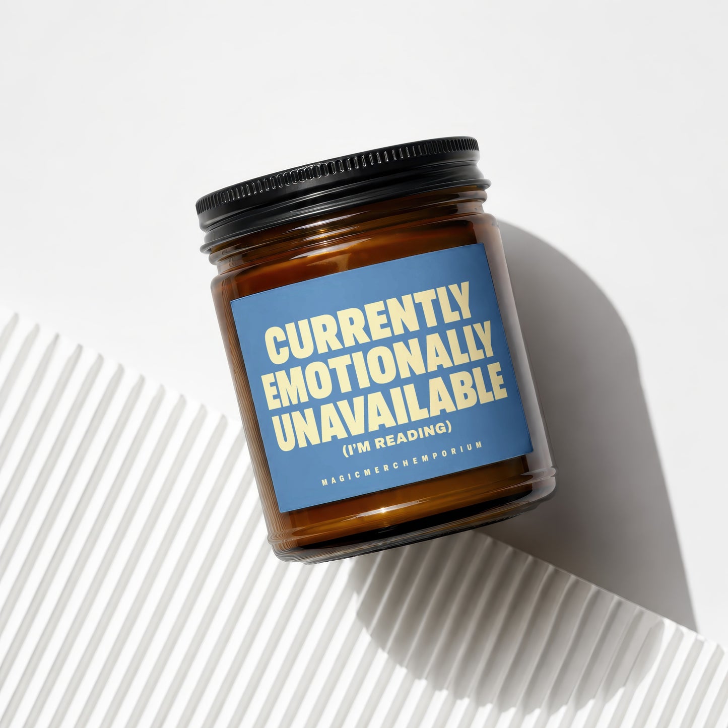 Brown candle in glass jar with blue label reading "Currently Emotionally Unavailable (I'm Reading)"