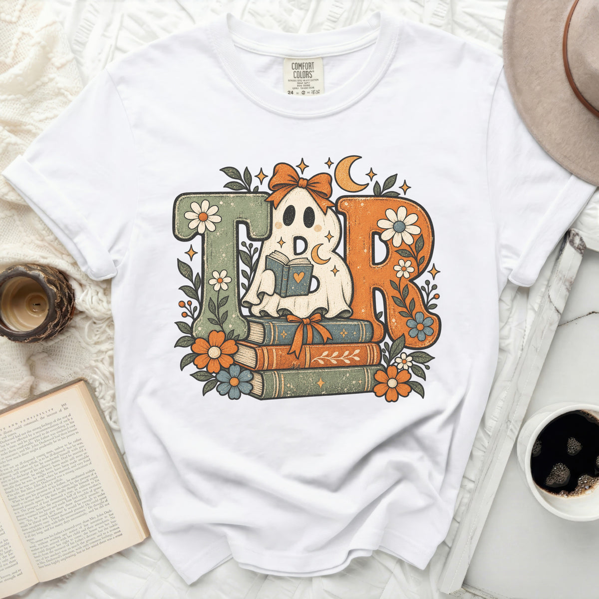 Retro ghost reading a book on stacks of books with flowers and moon graphic.