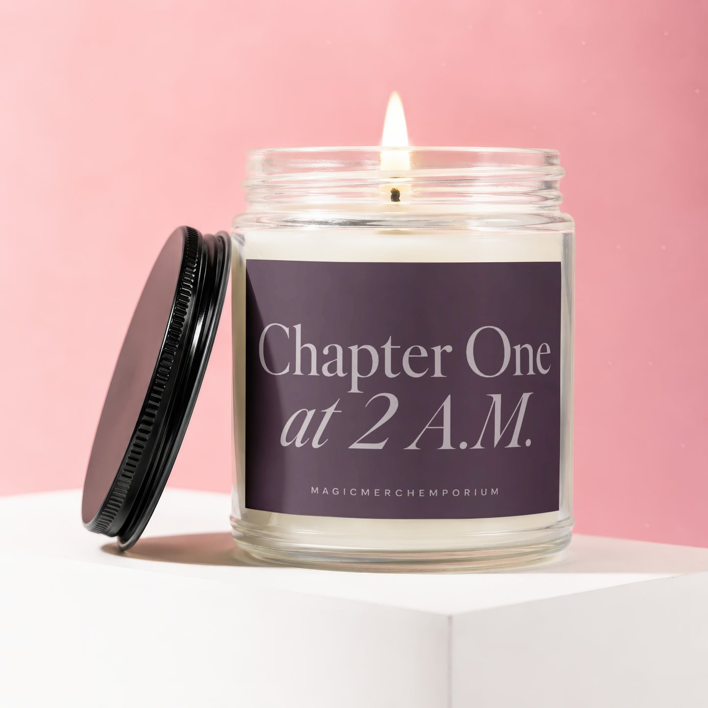 Lit glass jar candle with purple label reading "Chapter One at 2 A.M."
