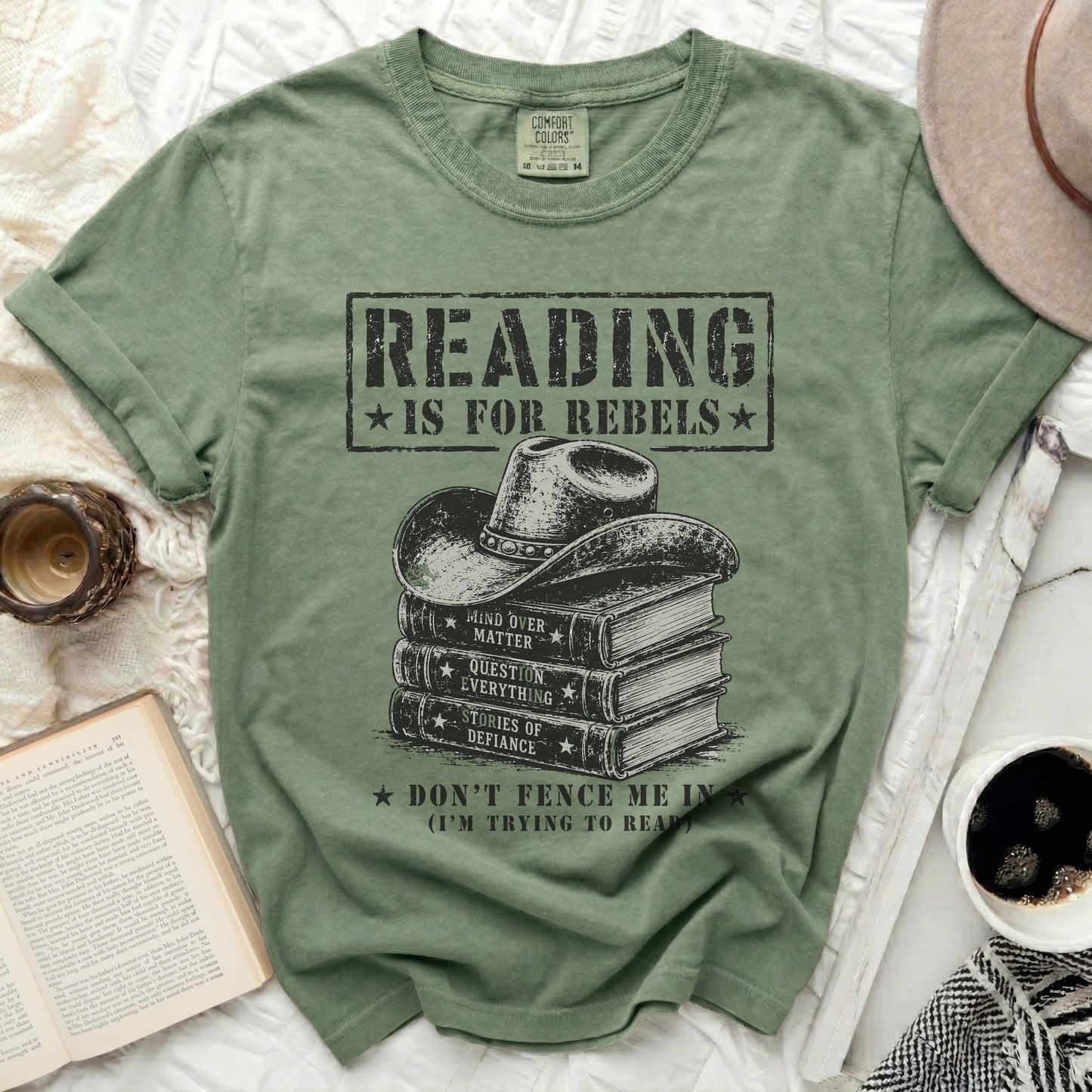 Green t-shirt with "Reading is for Rebels" and books topped by a cowboy hat.
