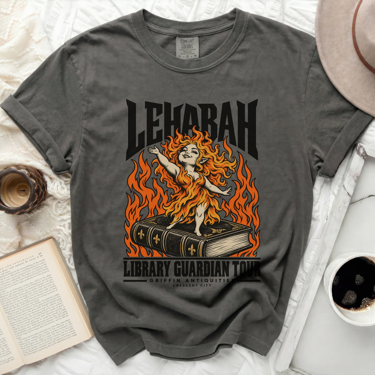 Charcoal t-shirt with "LEHABAH LIBRARY GUARDIAN TOUR" and a fire-haired creature on a book.