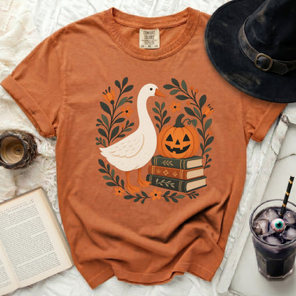 Orange t-shirt with a goose, pumpkin, and books graphic, Comfort Colors tag.