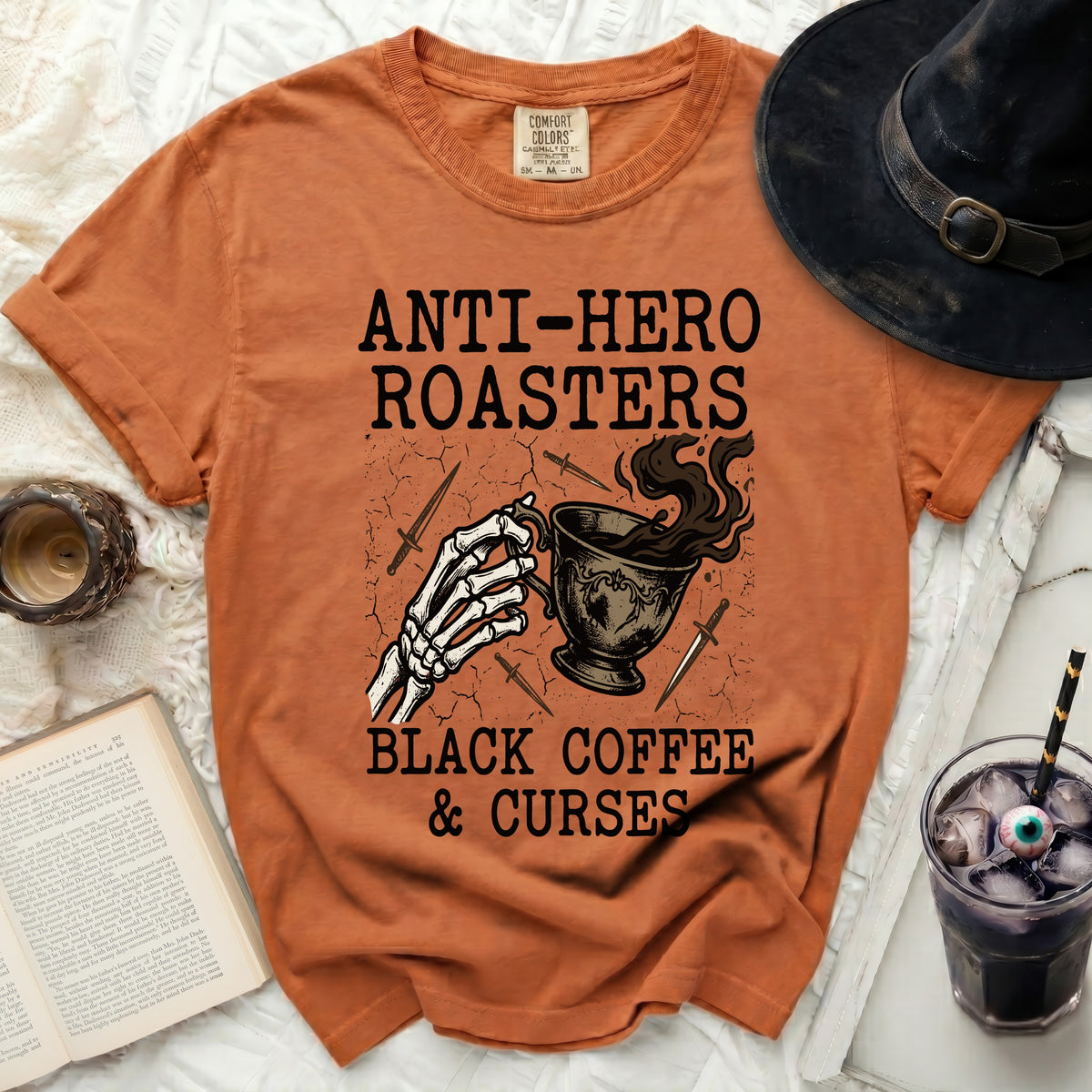 Orange t-shirt with "Anti-Hero Roasters Black Coffee & Curses" graphic and skeleton hand.