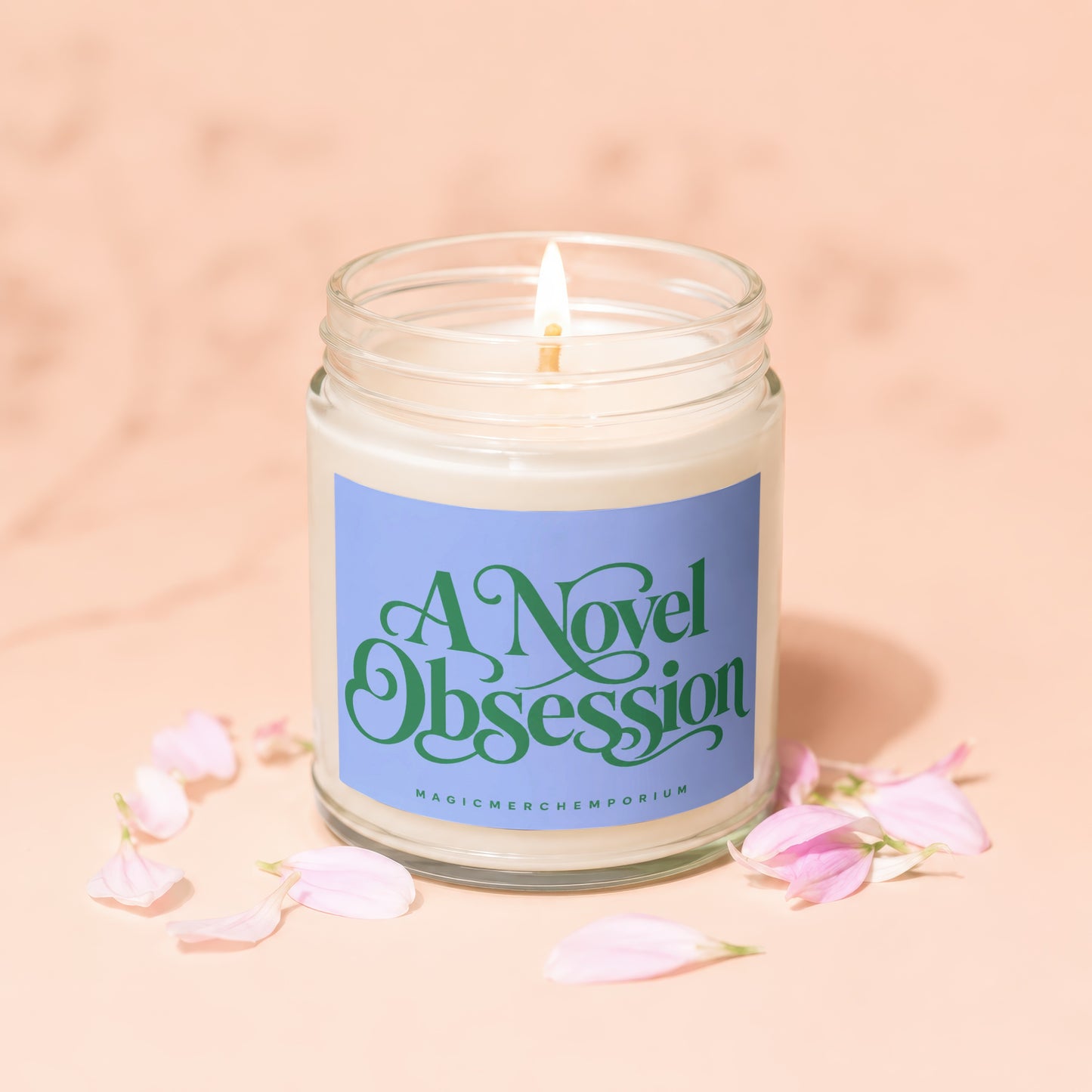 Glass jar candle with lit wick and "A Novel Obsession" label.