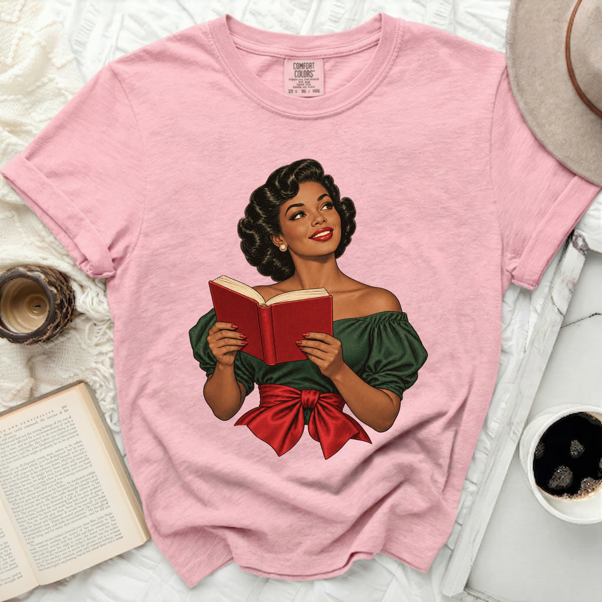 Pink t-shirt with illustration of a woman reading a book.