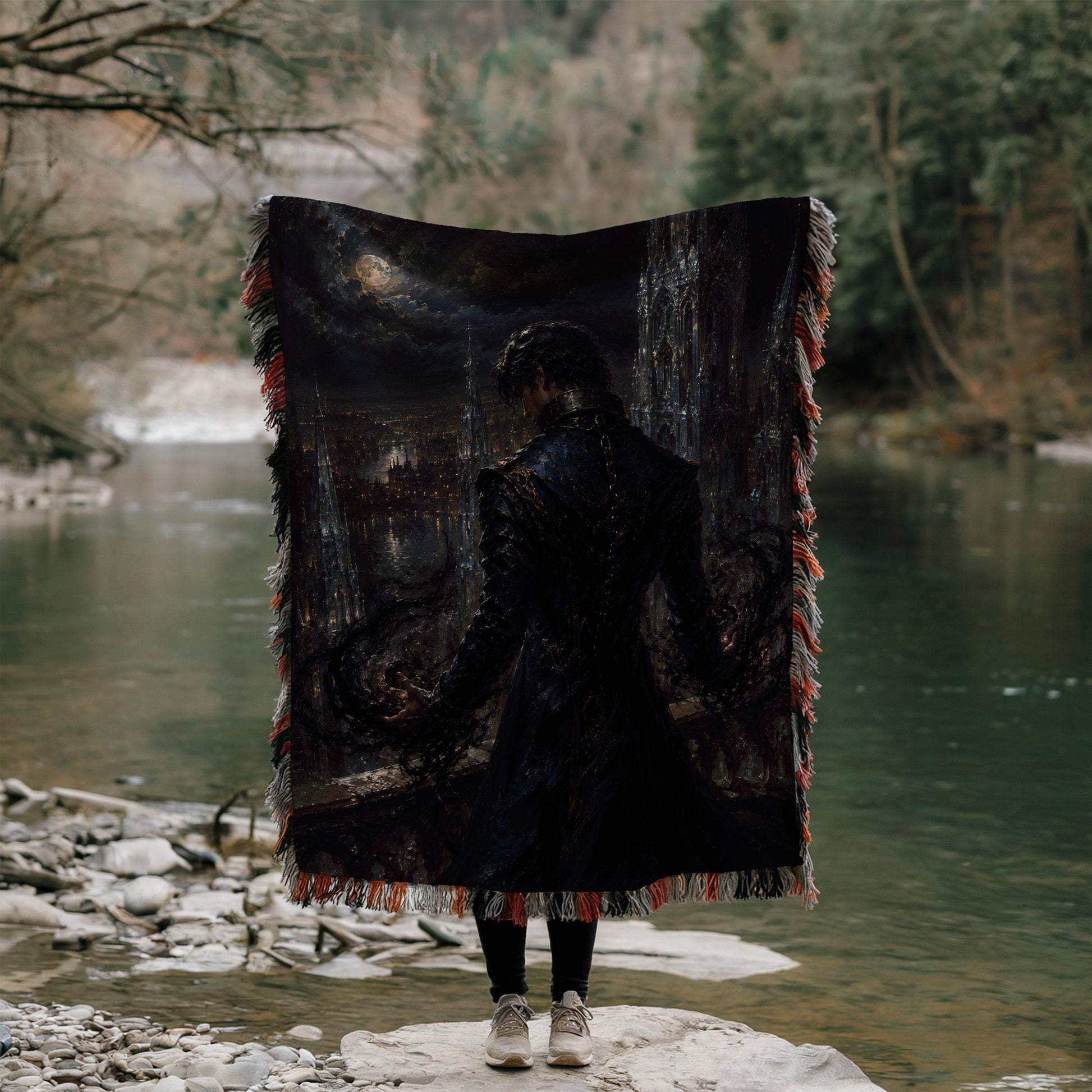 A person stands on a rock, holding a large, dark-colored blanket with a painting of a cityscape on it, facing a body of water.