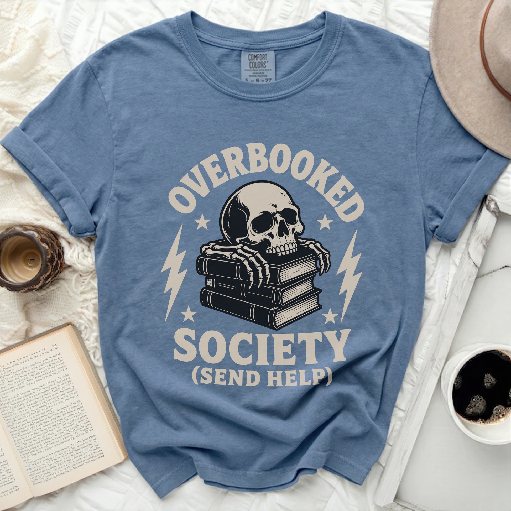 Blue t-shirt with skull on books and text "OVERBOOKED SOCIETY (SEND HELP)".
