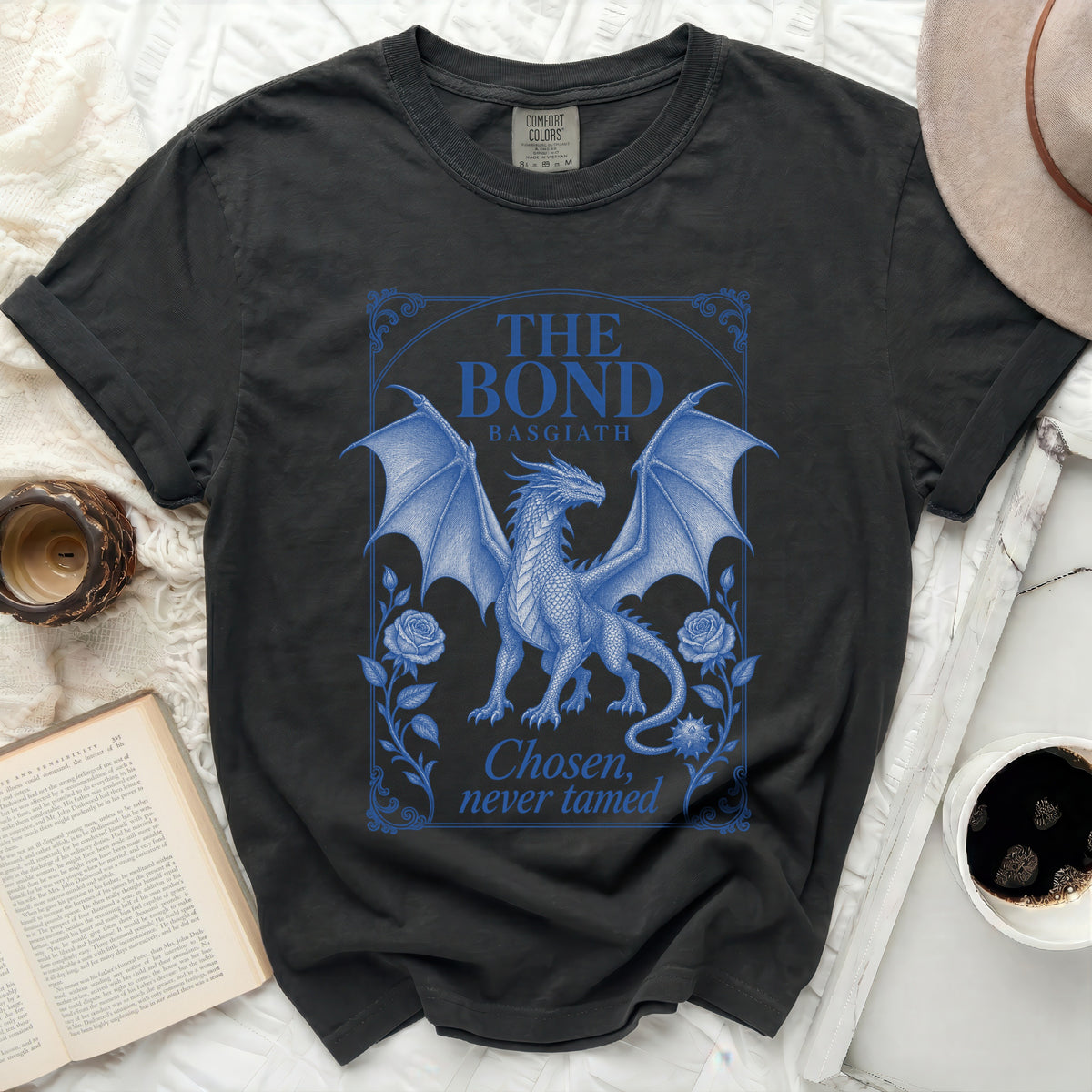 A black crewneck t-shirt featuring a blue graphic of a dragon, roses, and text reading The Bond Basgiath Chosen, never tamed.