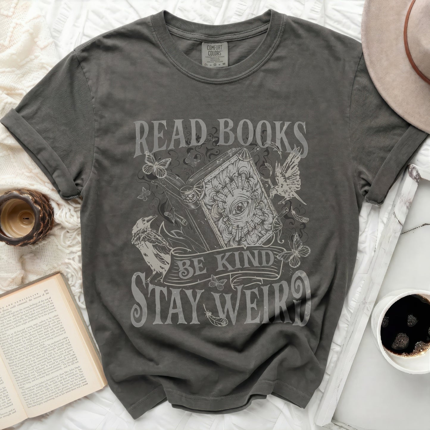 Gray t-shirt with "Read Books Be Kind Stay Weird" text and whimsical graphics.