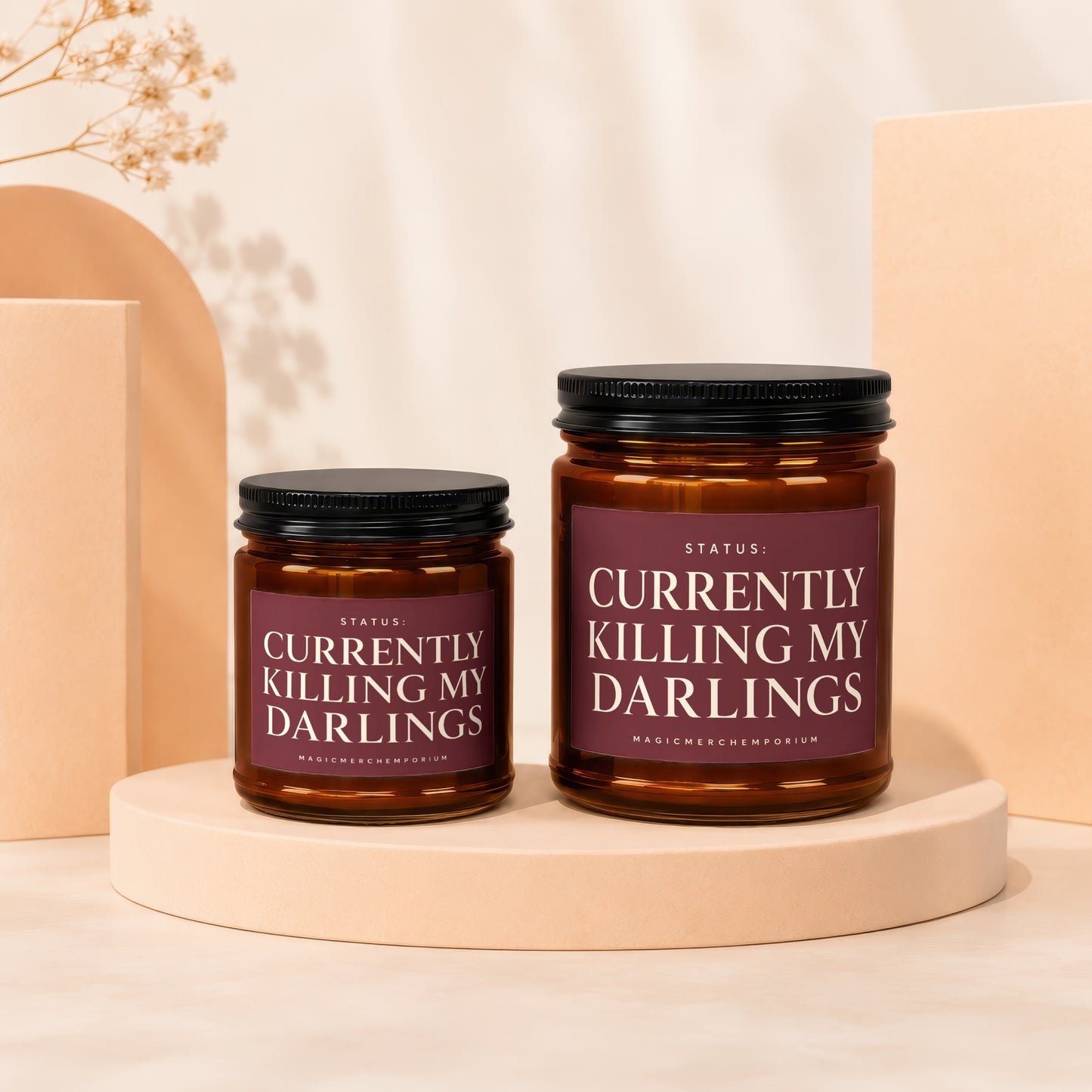 Two amber glass candles with black lids, labeled "Currently Killing My Darlings".