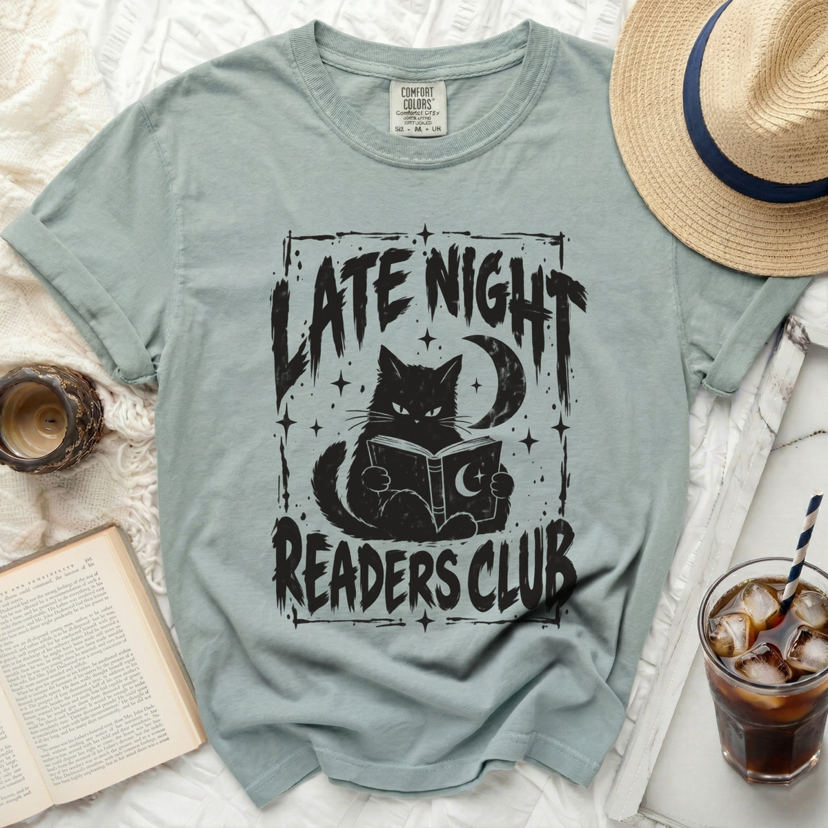 T-shirt with black graphic of a cat reading a book under a moon, with text "LATE NIGHT READERS CLUB".