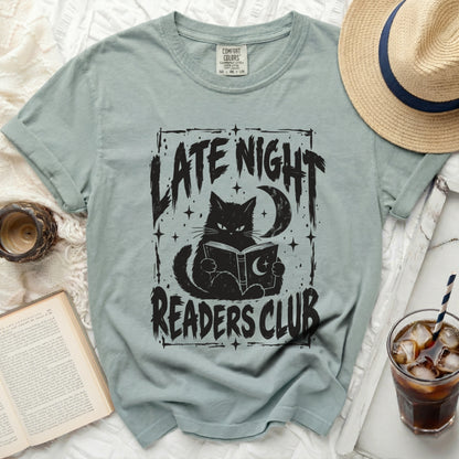 T-shirt with black graphic of a cat reading a book under a moon, with text "LATE NIGHT READERS CLUB".