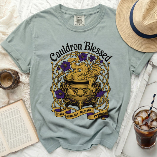 Light blue t-shirt with "Cauldron Blessed" and cauldron graphic.