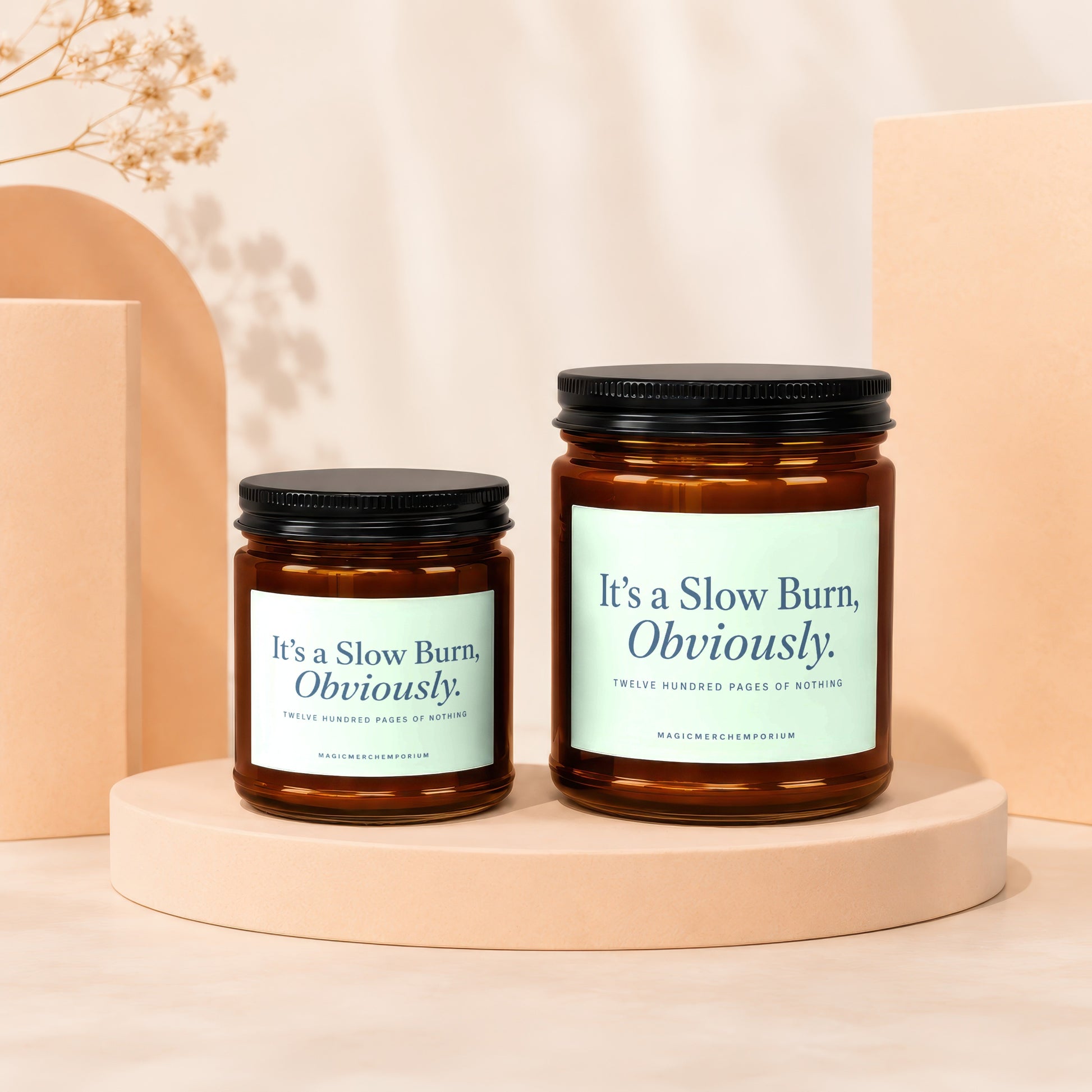 Two amber glass candles labeled "It's a Slow Burn, Obviously."