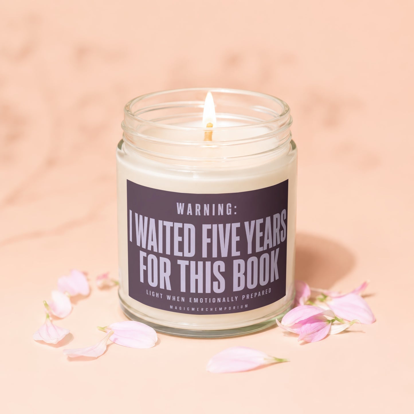 Lit candle in glass jar with "I waited five years for this book" warning label.