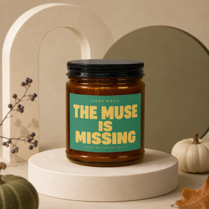 Amber jar candle with green label reading "LIGHT WHEN: THE MUSE IS MISSING"
