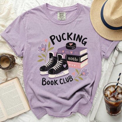 Purple t-shirt with ice skates, books, and "Pucking Book Club" text.