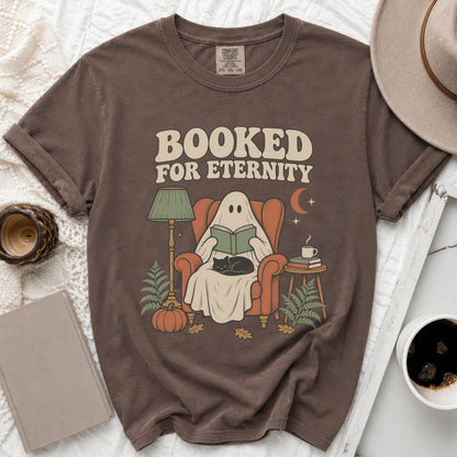Brown t-shirt graphic featuring a ghost reading with a cat and text "Booked For Eternity".