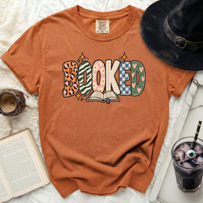 Orange t-shirt with "BOOKED" graphic and an open book.