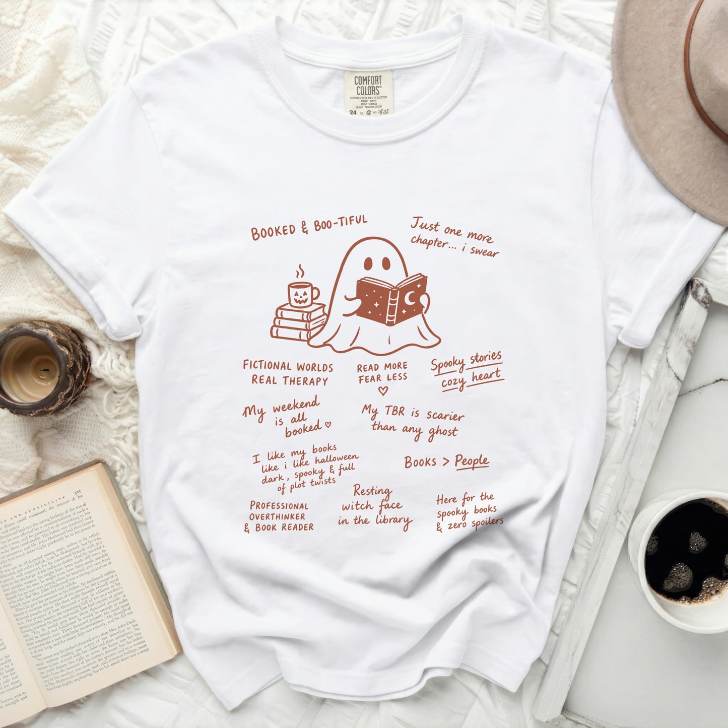 White t-shirt with ghost reading a book and spooky book-themed text.