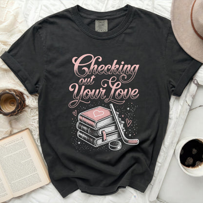 Black t-shirt with pink text "Checking Your Love" and stack of books.