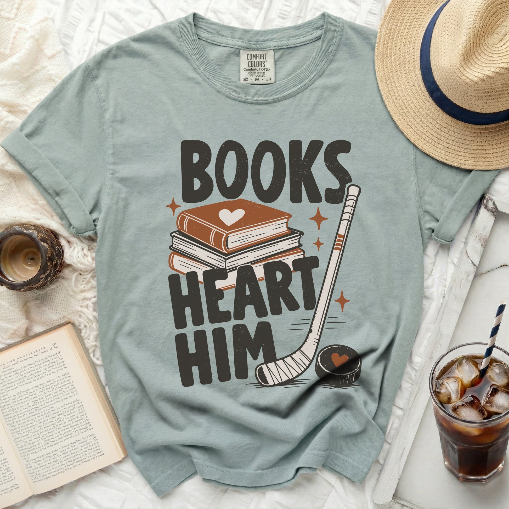 T-shirt with "Books Heart Him" text, stack of books, hockey stick, and puck.